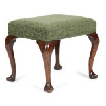 A GEORGE II WALNUT STOOL C.1730-40 the later stuffed-over seat, on cabriole legs and trefid feet