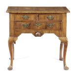 A GEORGE II WALNUT LOWBOY C.1725-30 the quarter veneered top with cross and feather banding, with