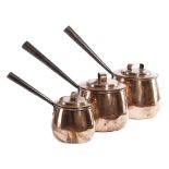 A VICTORIAN GRADUATED SET OF THREE COPPER SAUCEPANS BY BENHAM AND FROUD each with a lid, the handles