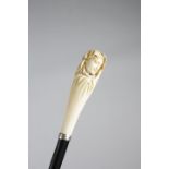 λ AN EDWARDIAN IVORY HANDLED WALKING CANE C.1910 carved in the form of a cloaked maiden, above a