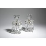 A PAIR OF CUT-GLASS LUSTRE CANDLESTICKS C.1820-30 each with a faceted urn shape socket, above a