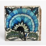 A William De Morgan Sands End Pottery large tile, painted with a fan flower in blue, green and black