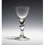 A light baluster wine glass c.1730, the conical bowl on a hollow inverted baluster stem with a basal