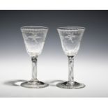 A pair of small wine glasses c.1750, the round funnel bowls engraved with birds in flight, raised on
