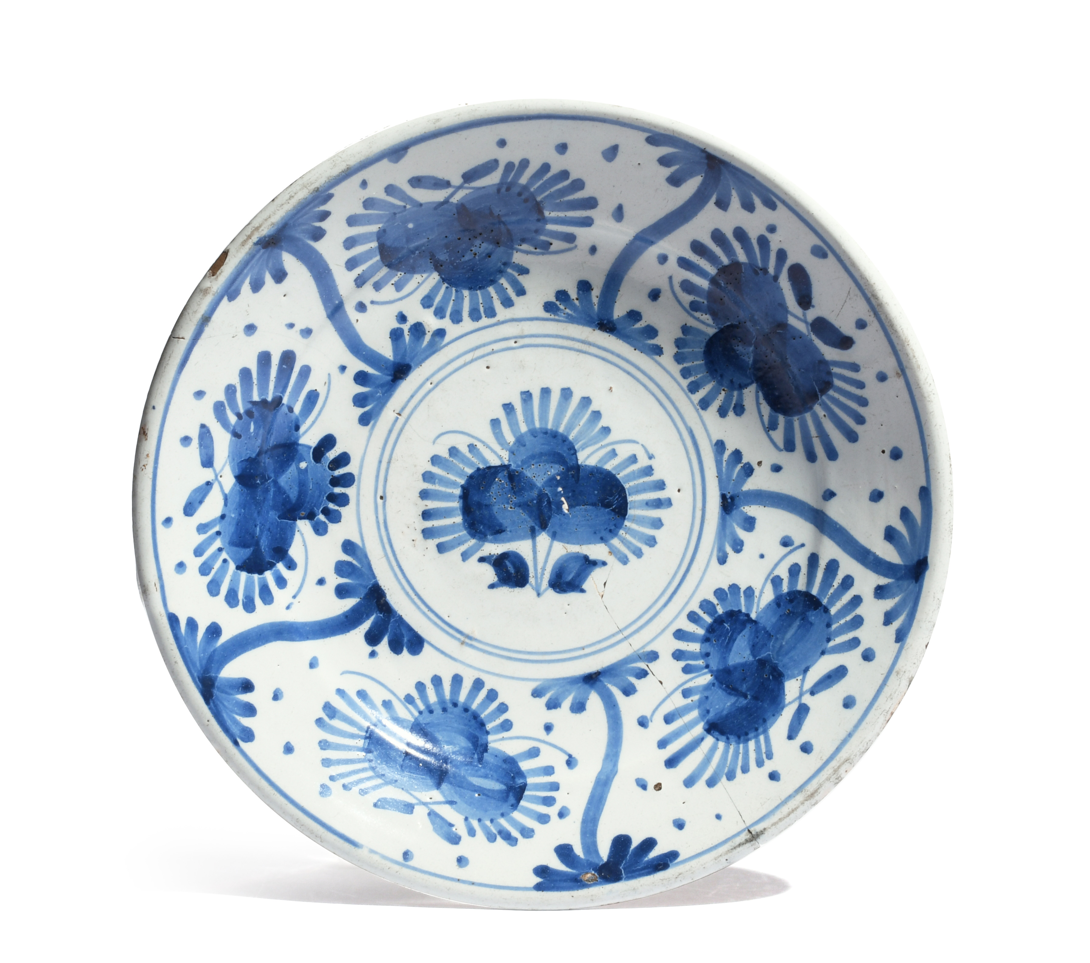 An early London delftware charger c.1660, painted in blue with a stylized flower to the well