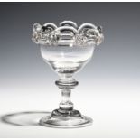 A sweetmeat glass c.1730, the ogee bowl applied with a looped border, raised on a baluster stem