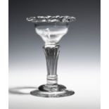 A sweetmeat glass c.1750, the bowl applied with a dog's tooth border above a pedestal stem and domed