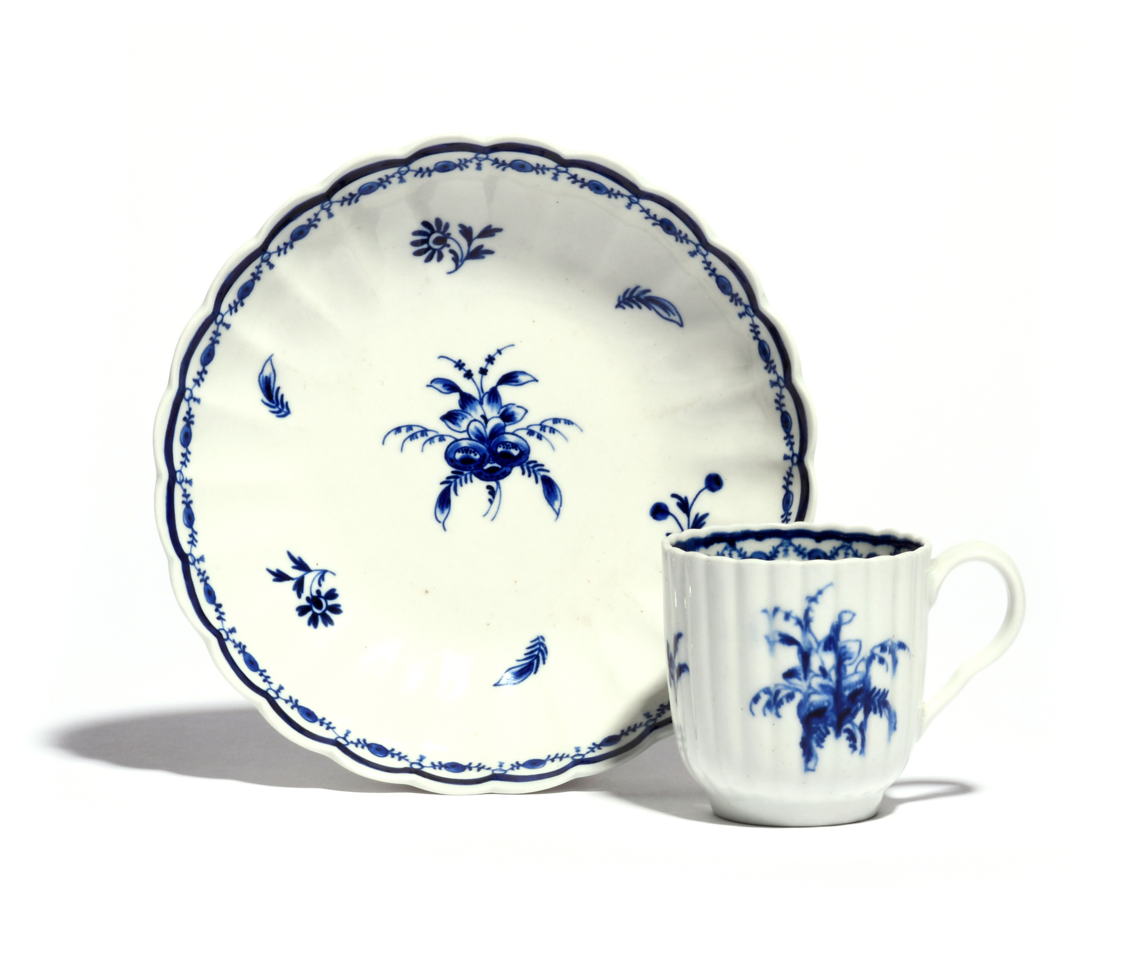 A Worcester blue and white coffee cup and associated saucer c.1780-90, the fluted forms painted with