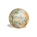 A small Castelli maiolica plate mid 18th century, painted in a typical muted palette with distant