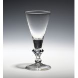 A wine glass c.1720, the deep conical bowl raised on a stem with angular and basal knops above a