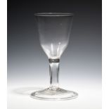 A large goblet c.1750, the generous ogee bowl raised on a plain hollow stem above a wide folded