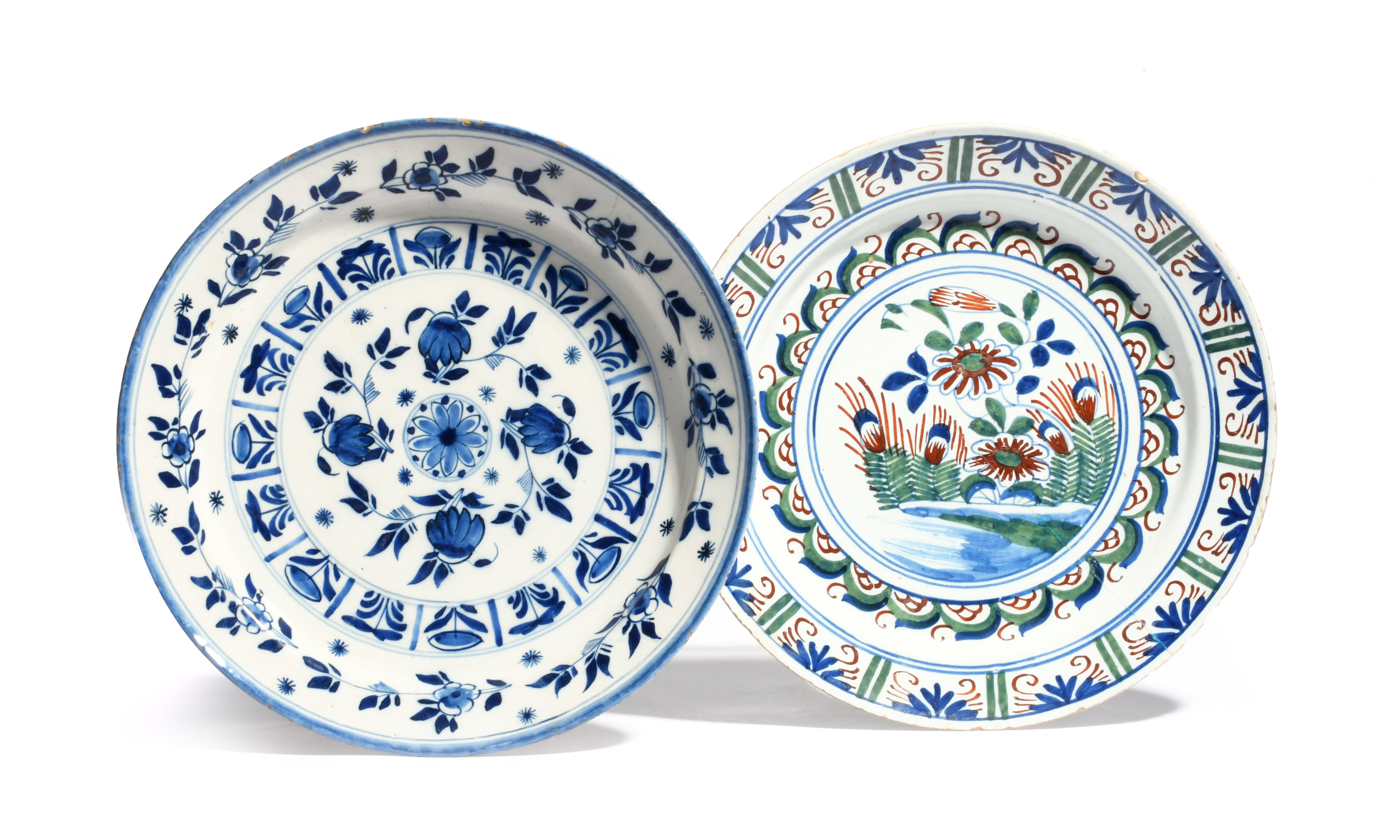 Two Bristol delftware chargers c.1735, one painted in red, green and blue with flowering branches