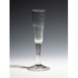 A ratafia glass c.1760, the round funnel bowl moulded with vertical flutes, raised on a plain stem