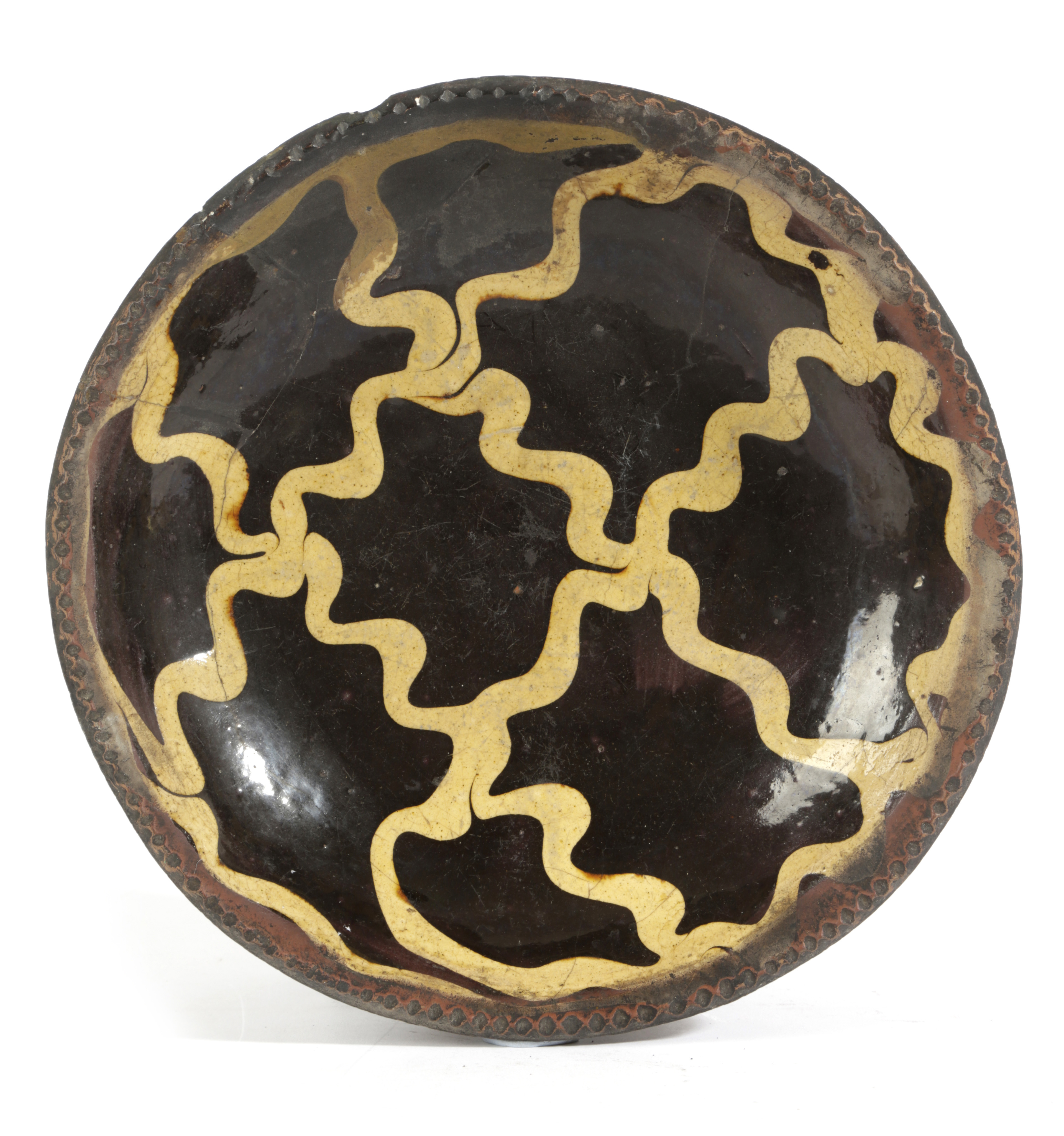 A STAFFORDSHIRE SLIPWARE POTTERY BOWL 18TH CENTURY with a crimped rim and decorated with a lattice