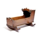 A VICTORIAN MAHOGANY AND PARCEL GILT DOLL'S CRADLE DATED '1863' with initials 'M.B.' 26.7cm high,