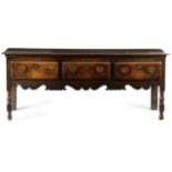 A GEORGE II OAK DRESSER C.1740-50 the boarded top with a moulded edge, above three frieze drawers,