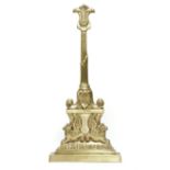 A BRASS DOORSTOP IN REGENCY STYLE EARLY 20TH CENTURY with a lappet and scroll handle and stem