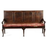 A GEORGE II OAK SETTLE MID-18TH CENTURY the back with quadruple fielded arched panels, with walnut