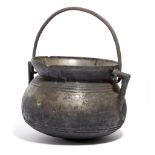 A BRONZE HANGING COOKING POT OR CAULDRON LATE 17TH CENTURY with angular lugs and a swing handle 17cm