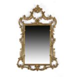 A GILT MIRROR IN ROCOCO STYLE 20TH CENTURY the rectangular plate in a scroll, rocaille and flower