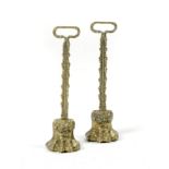 A MATCHED PAIR OF BRASS LION'S PAW DOORSTOPS 19TH CENTURY each with a foliate handle and stem, the