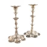 A pair of George II silver candlesticks, by John Cafe, London 1753, knopped baluster stems, shell