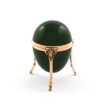 A gold mounted nephrite box, unmarked, egg form, plain mounts, hinged cover, on three ram's head
