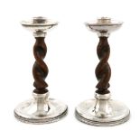 By A. E. Jones, a pair of Arts and Crafts silver and wood candlesticks, Birmingham 1924, with