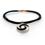 A circular rotating steel and black enamel pendant by Bulgari, with white gold suspension mount on a