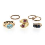 A collection of six rings, including a ruby and diamond-set gold snake ring, a blue topaz-set gold