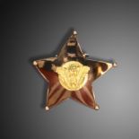 A gold, enamel and metal 'stars and stripes' brooch by Cartier, c1940, the upwardly curving star-