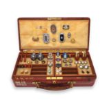 A brown leather jewellery case containing various items of jewellery, including a silver buckle with