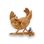 A gold bird brooch, the small bird flapping it's wings and set with ruby eyes and perched on a