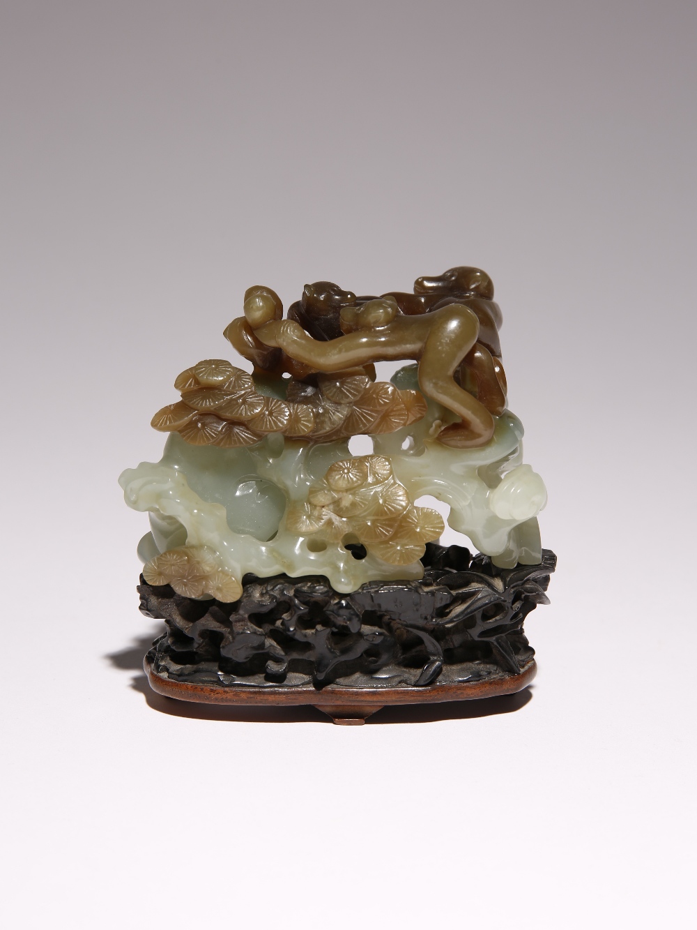 A CHINESE CELADON AND RUSSET JADE 'MONKEYS' GROUP 18TH/19TH CENTURY Deeply carved with three monkeys