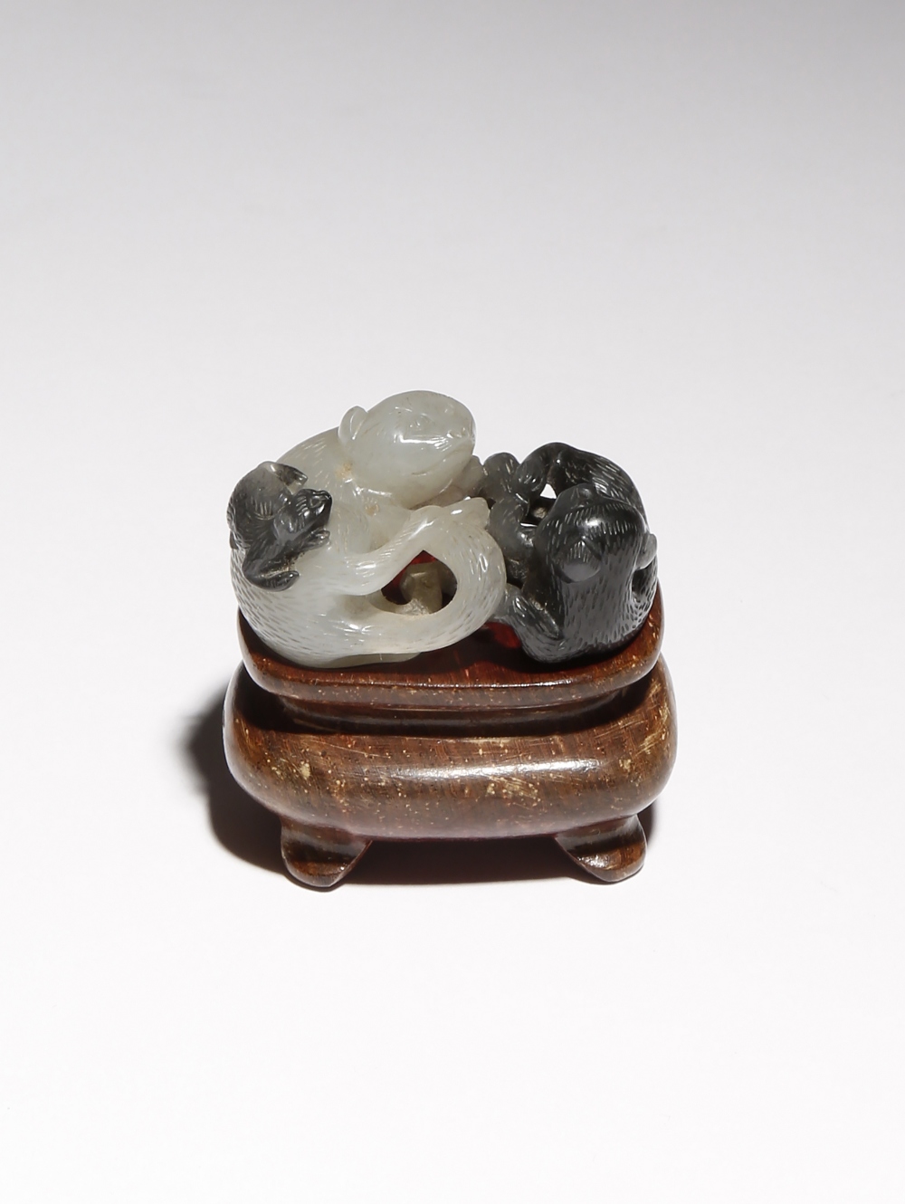 A SMALL CHINESE WHITE AND BLACK JADE CARVING OF CATS QING DYNASTY OR LATER Formed as two reclining