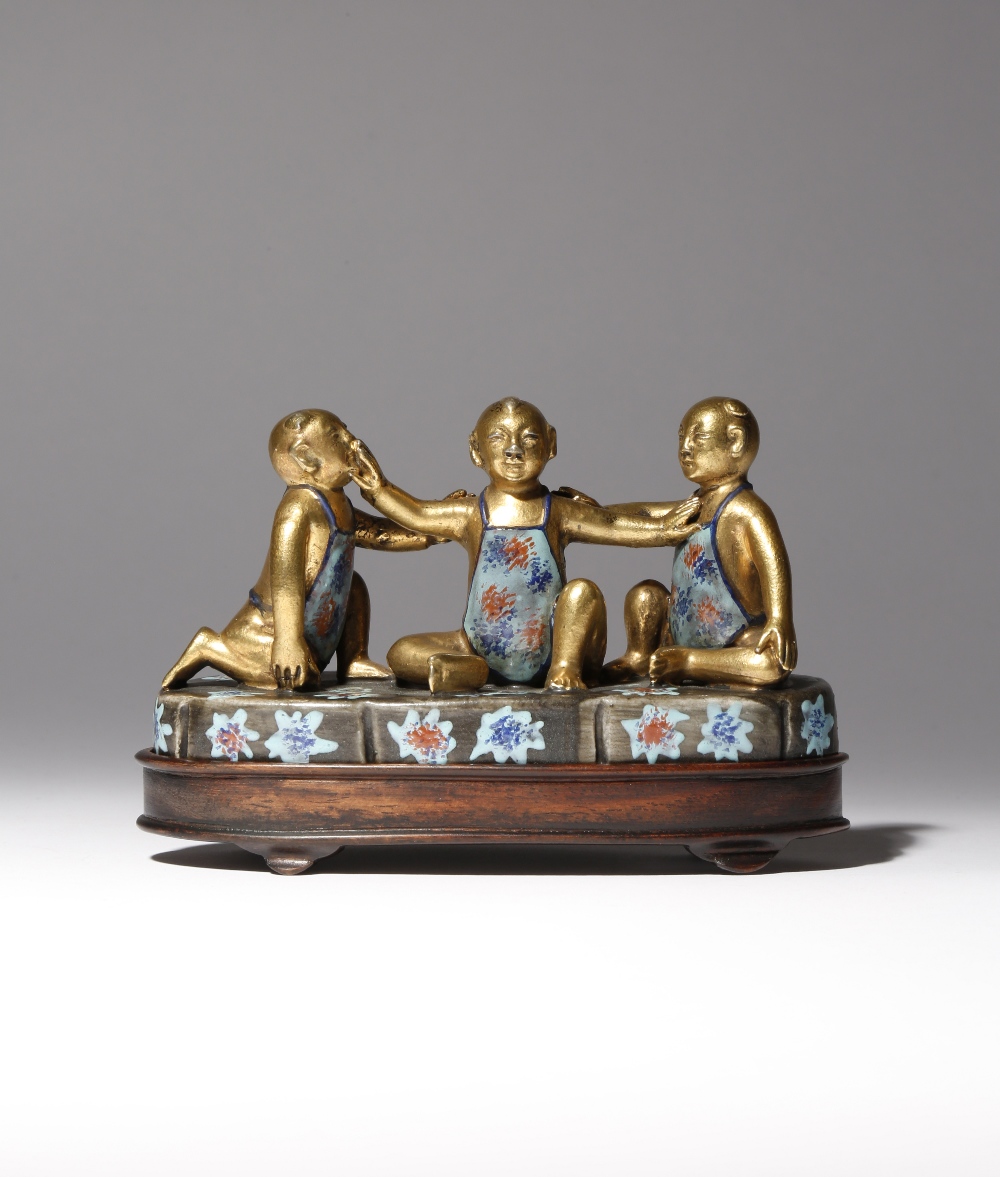 A CHINESE ENAMELLED AND GILT-DECORATED PORCELAIN MODEL OF THREE BOYS REPUBLIC PERIOD The three