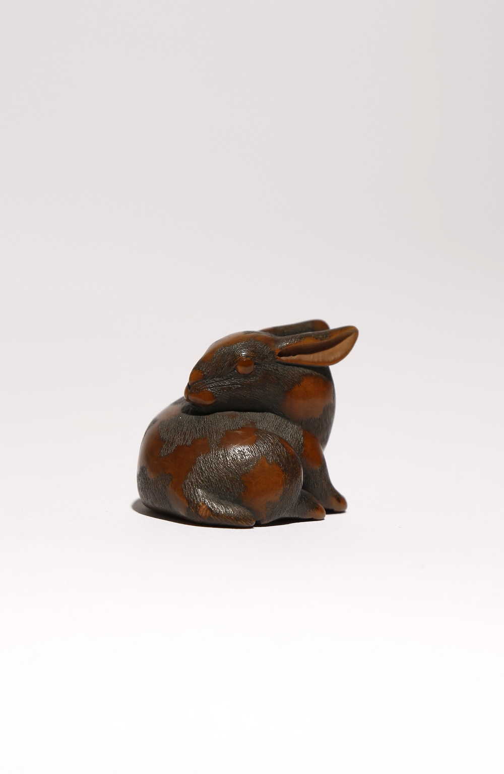 A JAPANESE WOOD NETSUKE OF A HARE WITH AMBER EYES EDO PERIOD, 19TH CENTURY Recumbant and with its - Image 3 of 3
