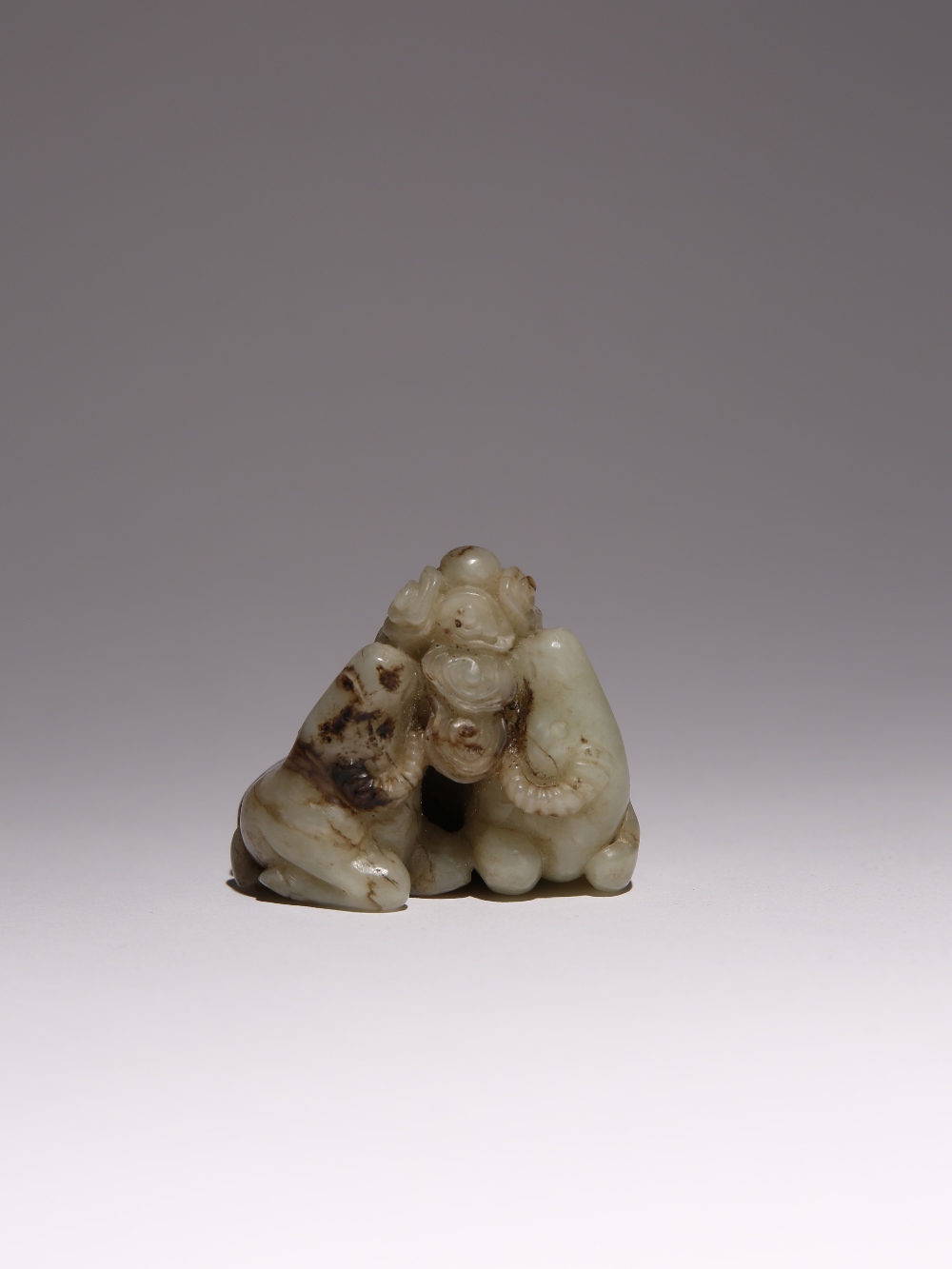 A CHINESE CELADON JADE CARVING OF TWO RAMS QING DYNASTY Formed as two recumbent rams lying side by