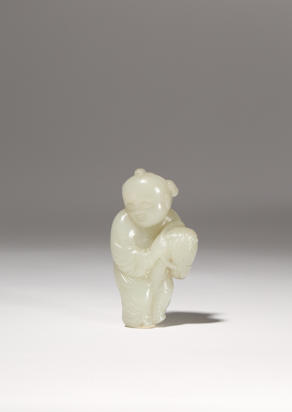 A CHINESE PALE CELADON JADE 'BOY' PENDANT QING DYNASTY OR LATER Carved as a young boy riding a hobby