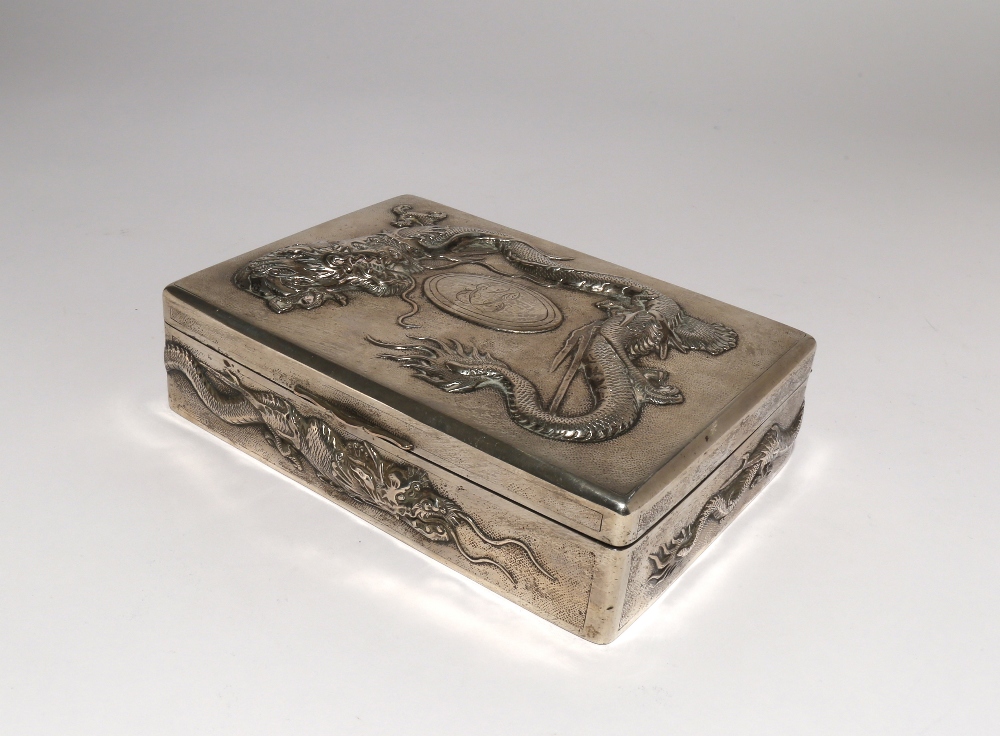 A CHINESE SILVER RECTANGULAR 'DRAGON' BOX LATE QING DYNASTY With a hinged cover, decorated in relief