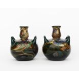 A pair of Gouda Pottery twin-handled vases, shape no.132, ovoid with twin loop handles, painted with