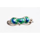 A Charles Horner silver and enamel brooch, cast in low relief with foliate panels, enamelled blue