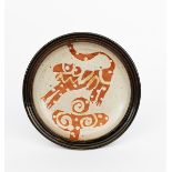 ‡John Maltby (1936-2020) a stoneware plate, resist decorated with a large cat and tree motif in iron