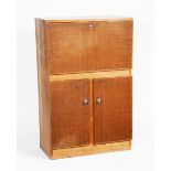 A Gordon Russell oak bureau, rectangular over twin door compartment, with polished metal