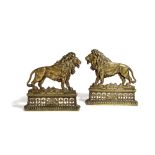 A PAIR OF BRASS LION FIREPLACE ORNAMENTS 19TH CENTURY titled 'The British Lion', above an arcaded