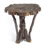 A RUSTIC STAINED ELM OCCASIONAL TABLE 19TH CENTURY the slab top with a bark edge and on primitive