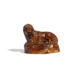 A POTTERY MODEL OF A RECUMBENT LION C.1840 with a treacle glaze 11.3cm high, 14cm wide Provenance