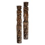 A PAIR OF CARVED OAK TERMS 17TH CENTURY with a saint figure, above a green man mask and ribbon