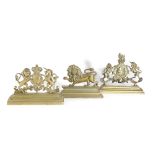 THREE BRASS FIREPLACE ORNAMENTS 19TH CENTURY comprising: two in the form of Royal Coats of Arms,