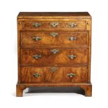 A GEORGE II WALNUT BACHELOR'S CHEST C.1725-30 with cross and feather banding, the hinged fold-over